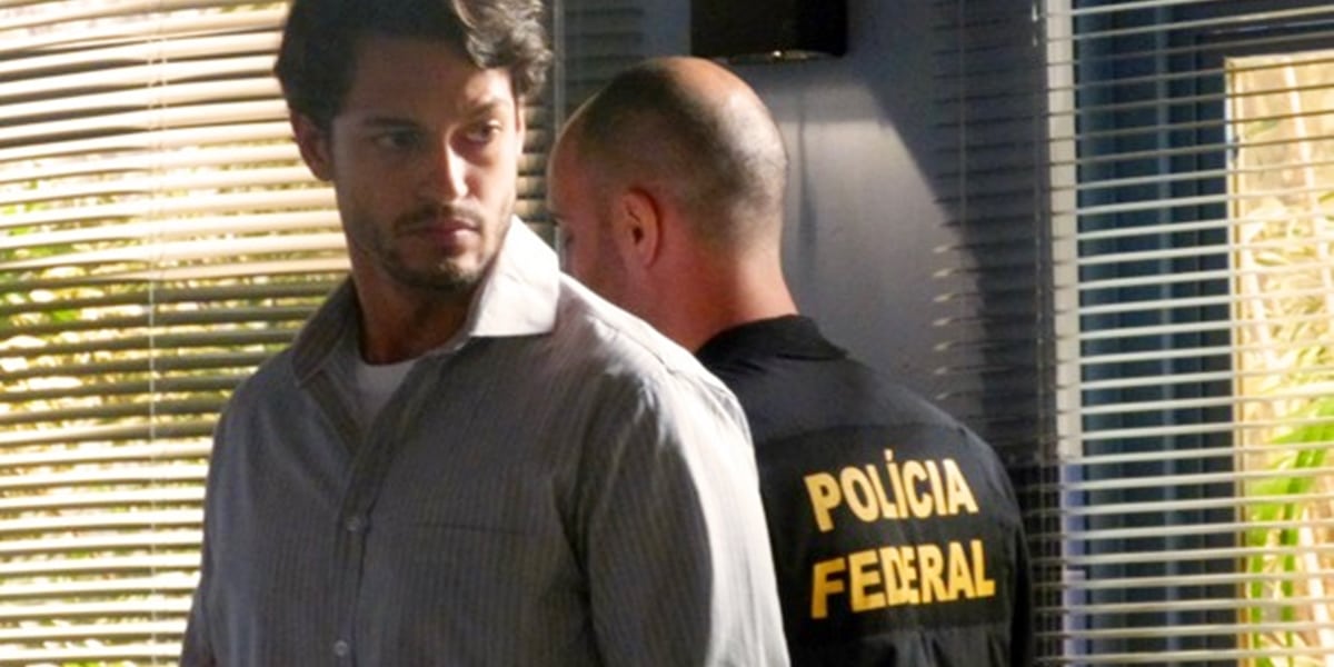 Hélio (Raphael Viana) recebe ameaça de Dionísio (Sérgio Mamberti) na prisão em Flor do Caribe (Foto: Reprodução/TV Globo)
